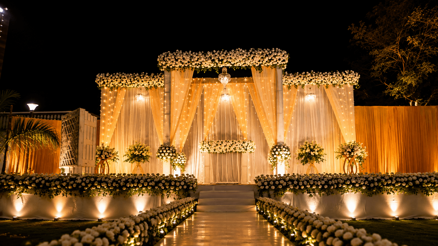 Wedding stage decorated with white drapes and florals at The City Crown Resort